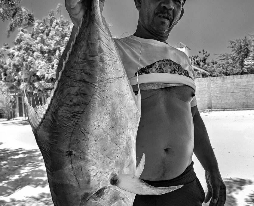 Piloia um pescador famoso na vila. segurando um peixe um peixe grande (foto petro e branco)
